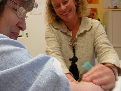 Die Angestellte einer Arztpraxis nimmt einer Patientin Blut ab