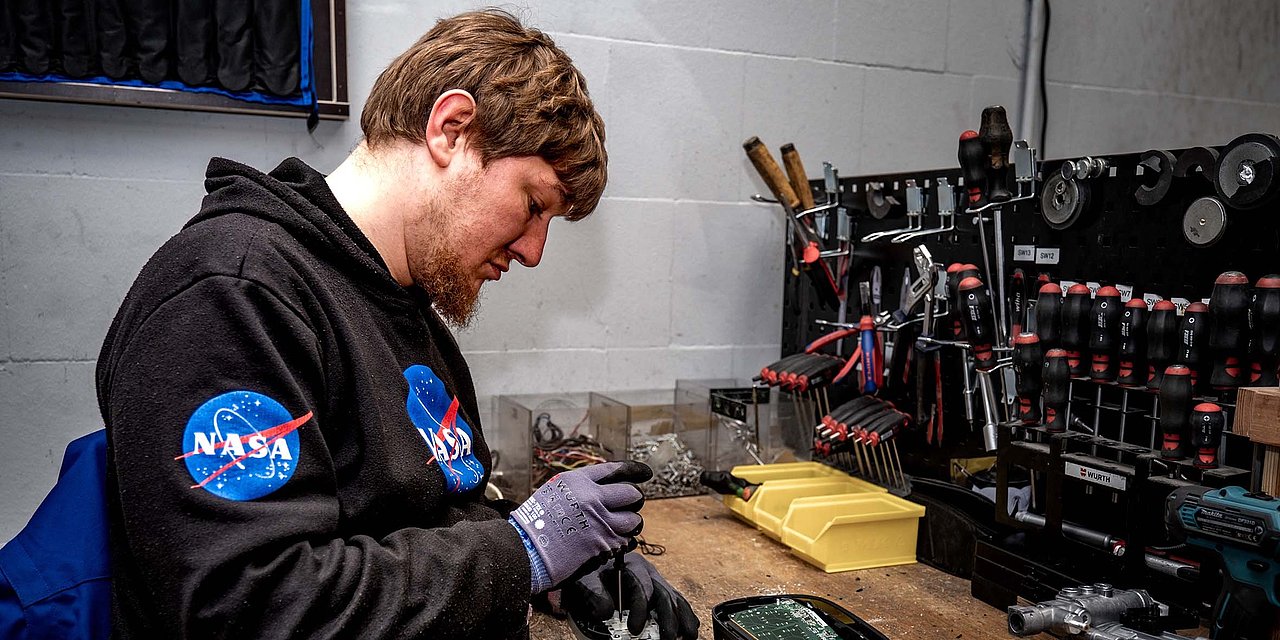 Ein junger Mann arbeitet an einer Werkbank