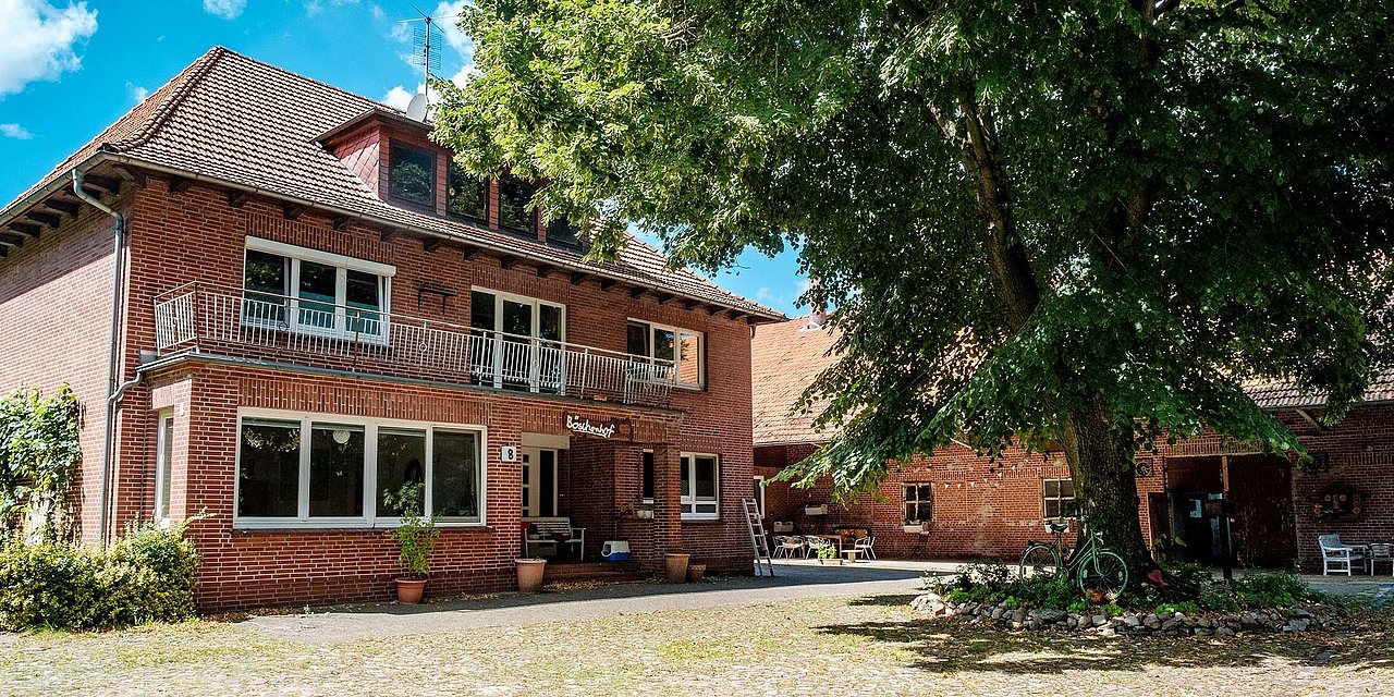 Das verklinkerte Haupthaus unter Bäumen in Unterstedt